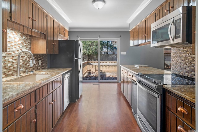 kitchen featuring tasteful backsplash, ornamental molding, stainless steel appliances, sink, and dark hardwood / wood-style floors