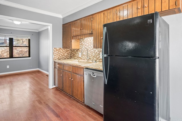 kitchen with dishwasher, sink, crown molding, fridge, and decorative backsplash