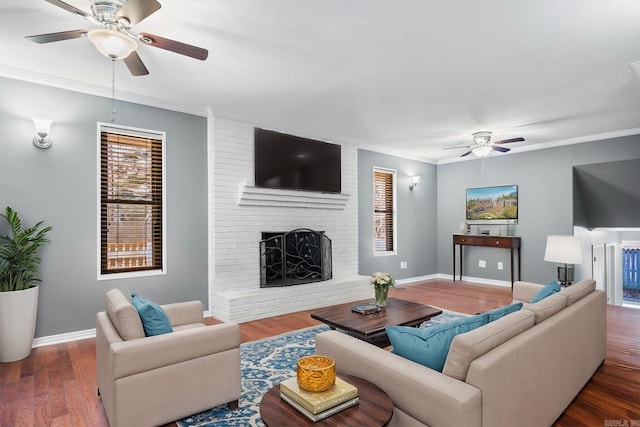 living room with ceiling fan, a fireplace, dark wood-type flooring, and ornamental molding