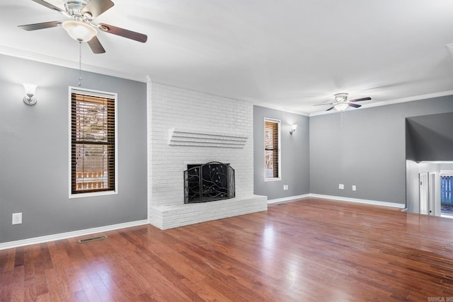 unfurnished living room with a fireplace, hardwood / wood-style floors, ceiling fan, and ornamental molding