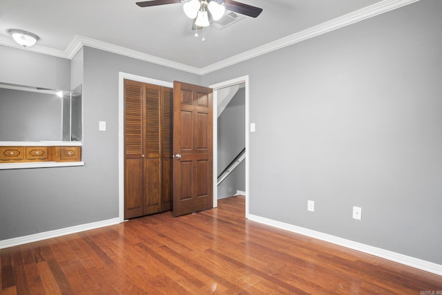 unfurnished bedroom featuring ceiling fan, ornamental molding, and hardwood / wood-style flooring