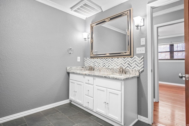 bathroom with tile patterned floors, decorative backsplash, crown molding, and vanity