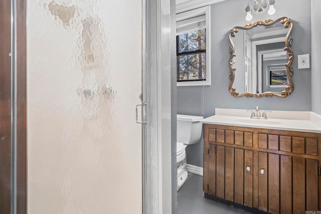 bathroom featuring vanity, an enclosed shower, and toilet