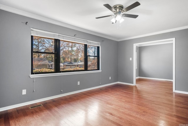 empty room featuring hardwood / wood-style flooring, ceiling fan, and ornamental molding