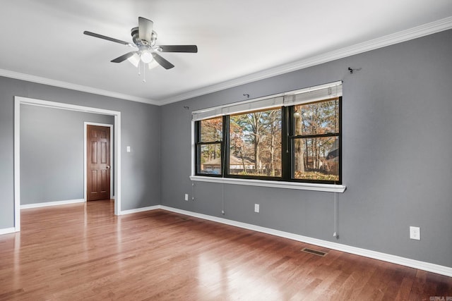 spare room featuring hardwood / wood-style floors, ceiling fan, and crown molding