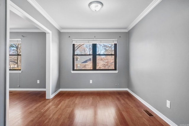 unfurnished room featuring wood-type flooring and crown molding