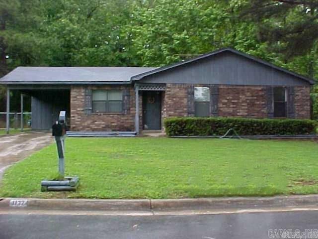 single story home featuring a front yard and a carport