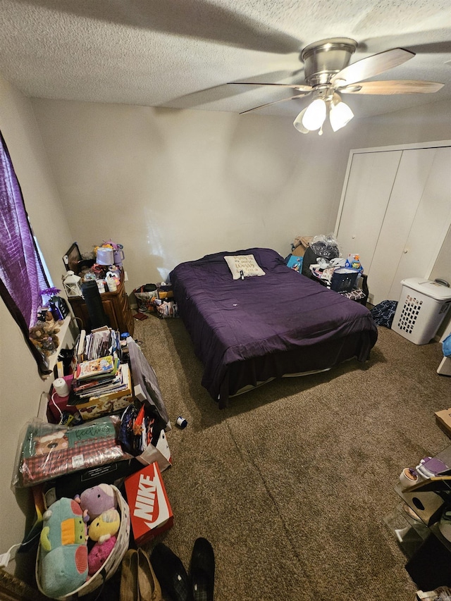 carpeted bedroom with ceiling fan, a closet, and a textured ceiling