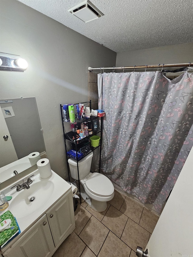 bathroom featuring curtained shower, tile patterned flooring, a textured ceiling, toilet, and vanity