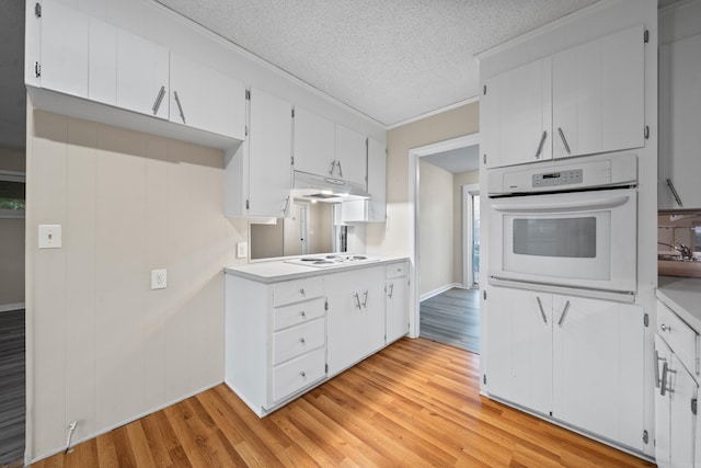 kitchen featuring white cabinets, white oven, and light hardwood / wood-style flooring