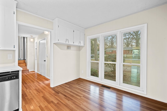 kitchen with dishwasher, white cabinets, a textured ceiling, and light hardwood / wood-style flooring