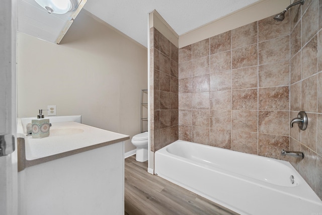 full bathroom with vanity, toilet, wood-type flooring, and tiled shower / bath combo