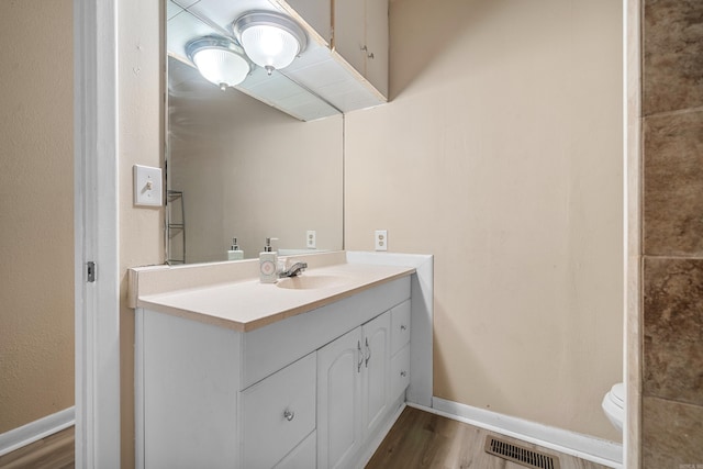 bathroom featuring hardwood / wood-style floors, vanity, and toilet