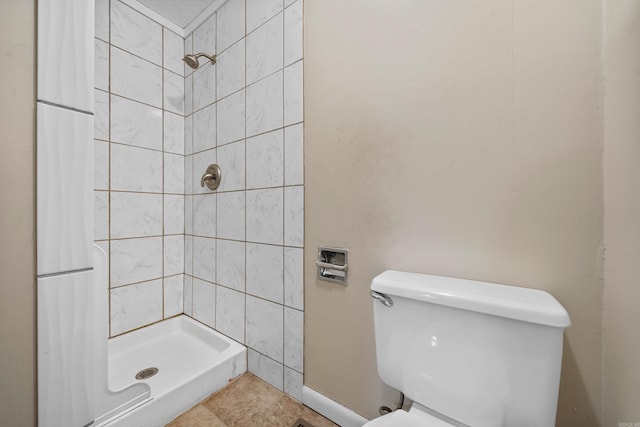 bathroom featuring toilet and a tile shower