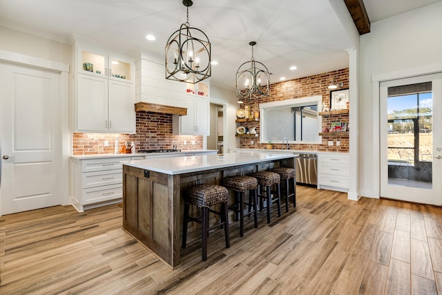 kitchen featuring white cabinets, decorative backsplash, a kitchen island, and a breakfast bar area