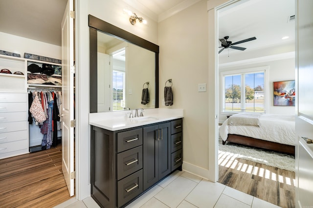 bathroom with tile patterned flooring, ceiling fan, ornamental molding, and vanity