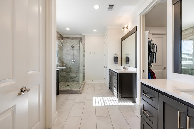 bathroom with vanity, tile patterned floors, a shower with door, and ornamental molding