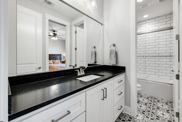 full bathroom with ceiling fan, tiled shower / bath combo, tile patterned floors, toilet, and vanity