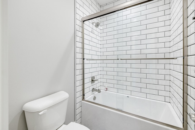 bathroom featuring toilet and combined bath / shower with glass door