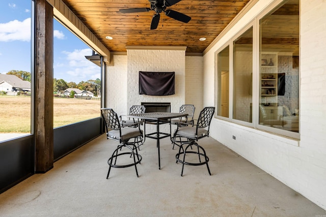 sunroom featuring ceiling fan and wood ceiling