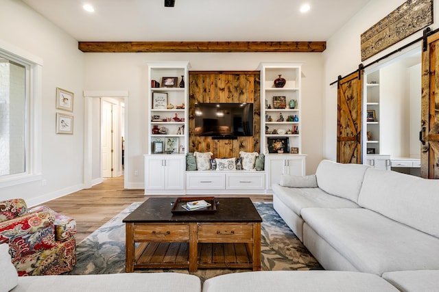 living room with a barn door and hardwood / wood-style flooring