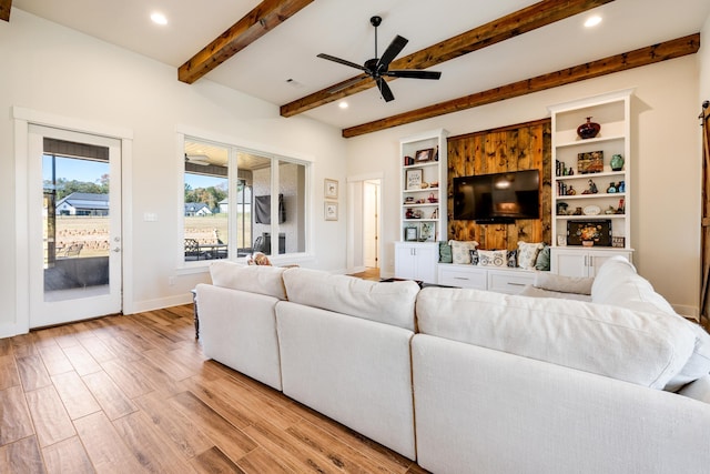 living room featuring beam ceiling, light hardwood / wood-style floors, and ceiling fan