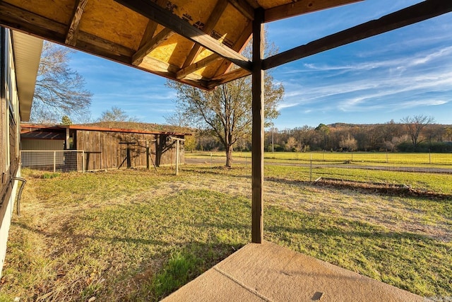 view of yard with a rural view and an outdoor structure