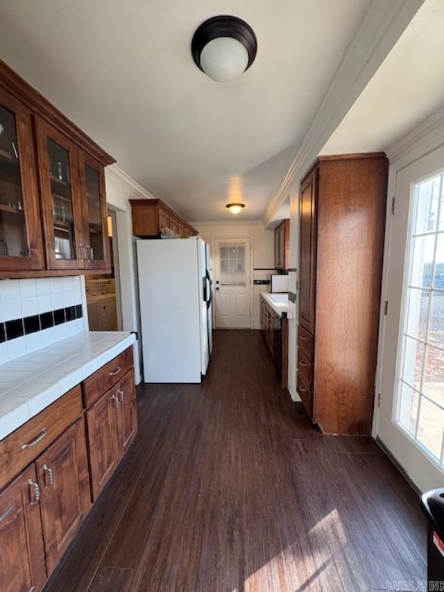 kitchen with backsplash, dark hardwood / wood-style flooring, white fridge, and ornamental molding