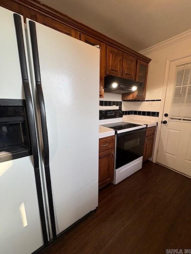 kitchen featuring dark hardwood / wood-style floors, white appliances, ornamental molding, and tasteful backsplash