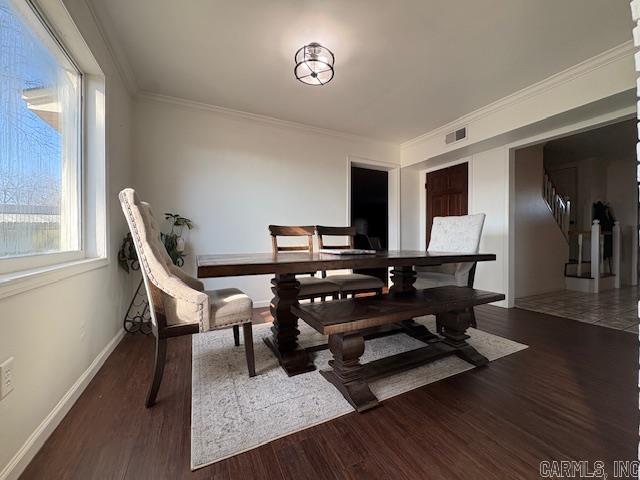 dining area featuring crown molding and dark wood-type flooring