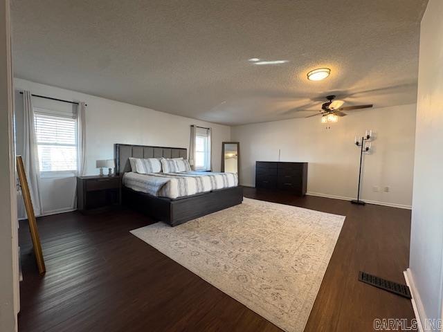 unfurnished bedroom featuring a textured ceiling, dark hardwood / wood-style floors, and ceiling fan