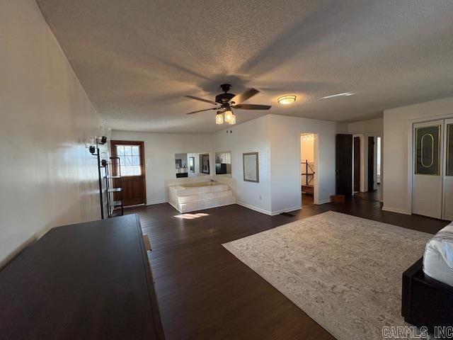 living room with ceiling fan, dark hardwood / wood-style flooring, and a textured ceiling