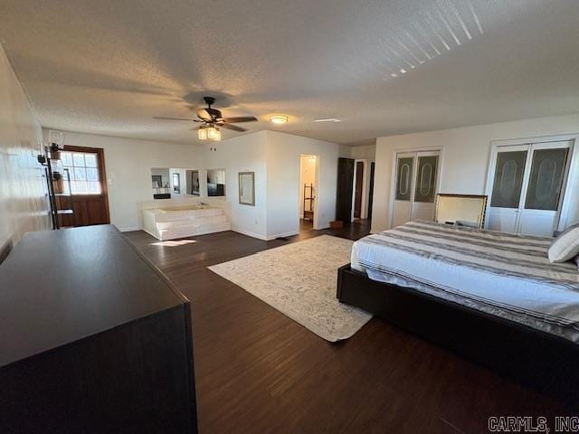 bedroom featuring ceiling fan, dark hardwood / wood-style floors, and a textured ceiling