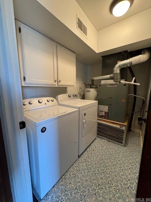 laundry room featuring cabinets, independent washer and dryer, and strapped water heater