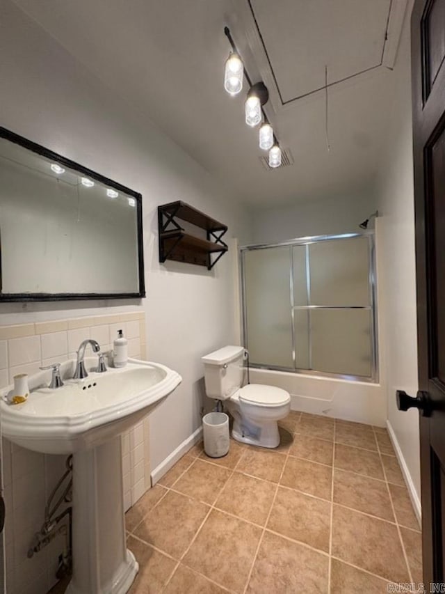 full bathroom featuring tile patterned floors, toilet, shower / bath combination with glass door, and backsplash