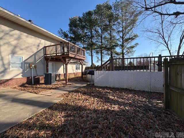 view of yard featuring central AC unit and a wooden deck