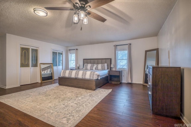 unfurnished bedroom featuring multiple windows, ceiling fan, dark hardwood / wood-style floors, and a textured ceiling