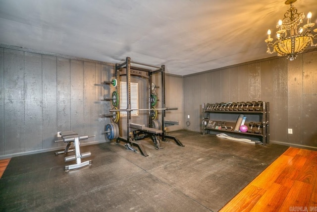 exercise room featuring hardwood / wood-style flooring and a notable chandelier