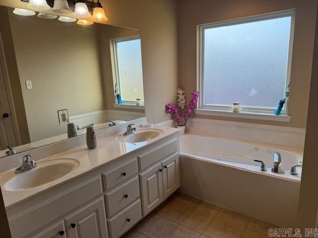 bathroom with a tub, tile patterned flooring, and vanity