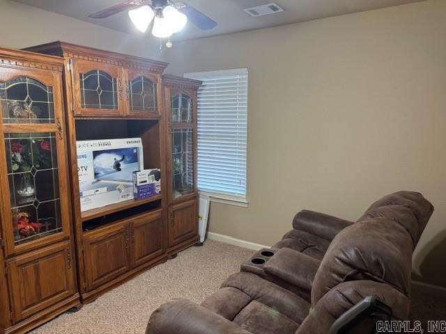 carpeted living room with ceiling fan