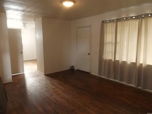 empty room with dark hardwood / wood-style floors and ceiling fan