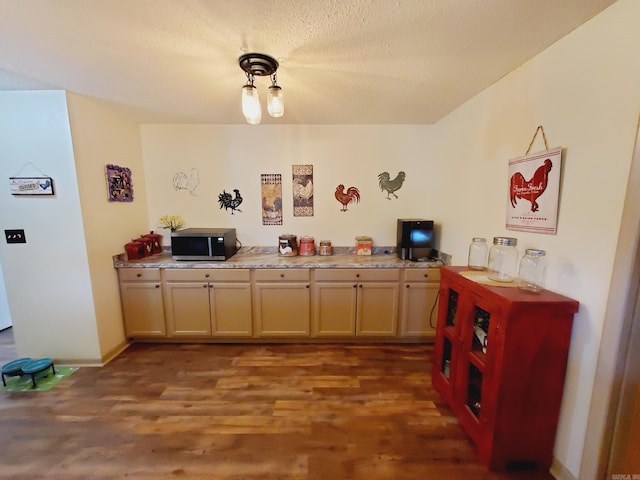 kitchen with a textured ceiling and dark hardwood / wood-style floors