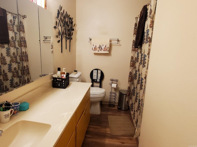 bathroom with wood-type flooring, vanity, and toilet