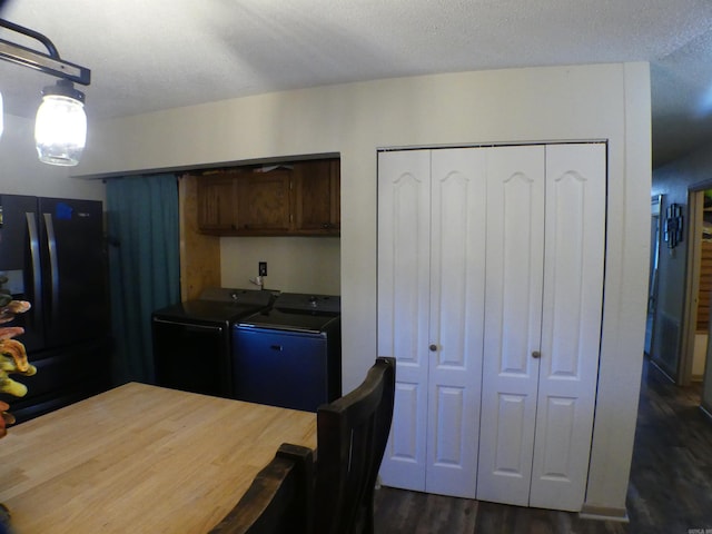 kitchen featuring a textured ceiling, separate washer and dryer, black fridge, and dark hardwood / wood-style floors