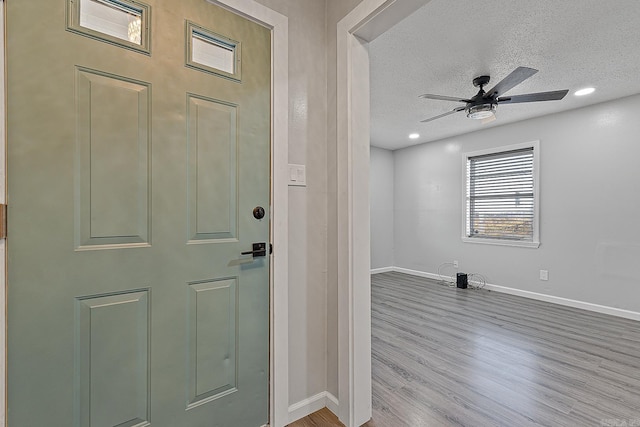 foyer with a textured ceiling, light hardwood / wood-style floors, and ceiling fan