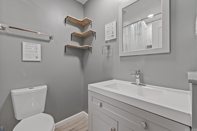 bathroom featuring hardwood / wood-style floors, vanity, toilet, and a textured ceiling