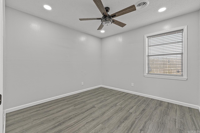 empty room with hardwood / wood-style flooring, ceiling fan, and a textured ceiling