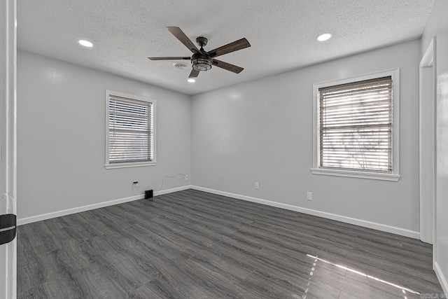 spare room with dark hardwood / wood-style floors, ceiling fan, and a textured ceiling