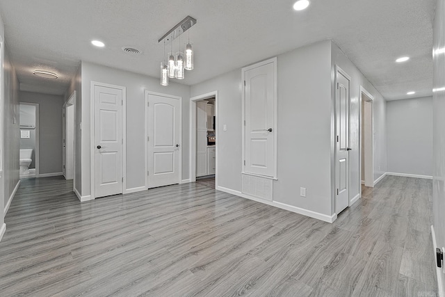 interior space with light wood-type flooring and a textured ceiling