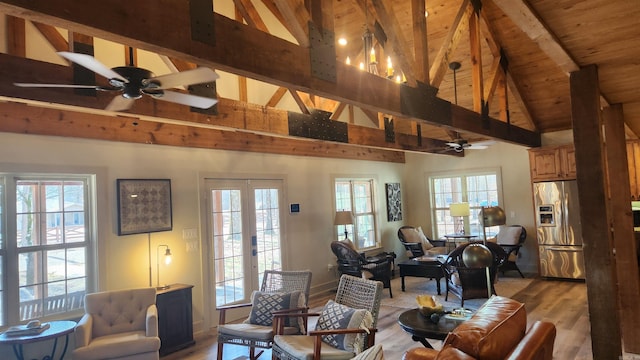 living room with ceiling fan, beam ceiling, light hardwood / wood-style flooring, and french doors